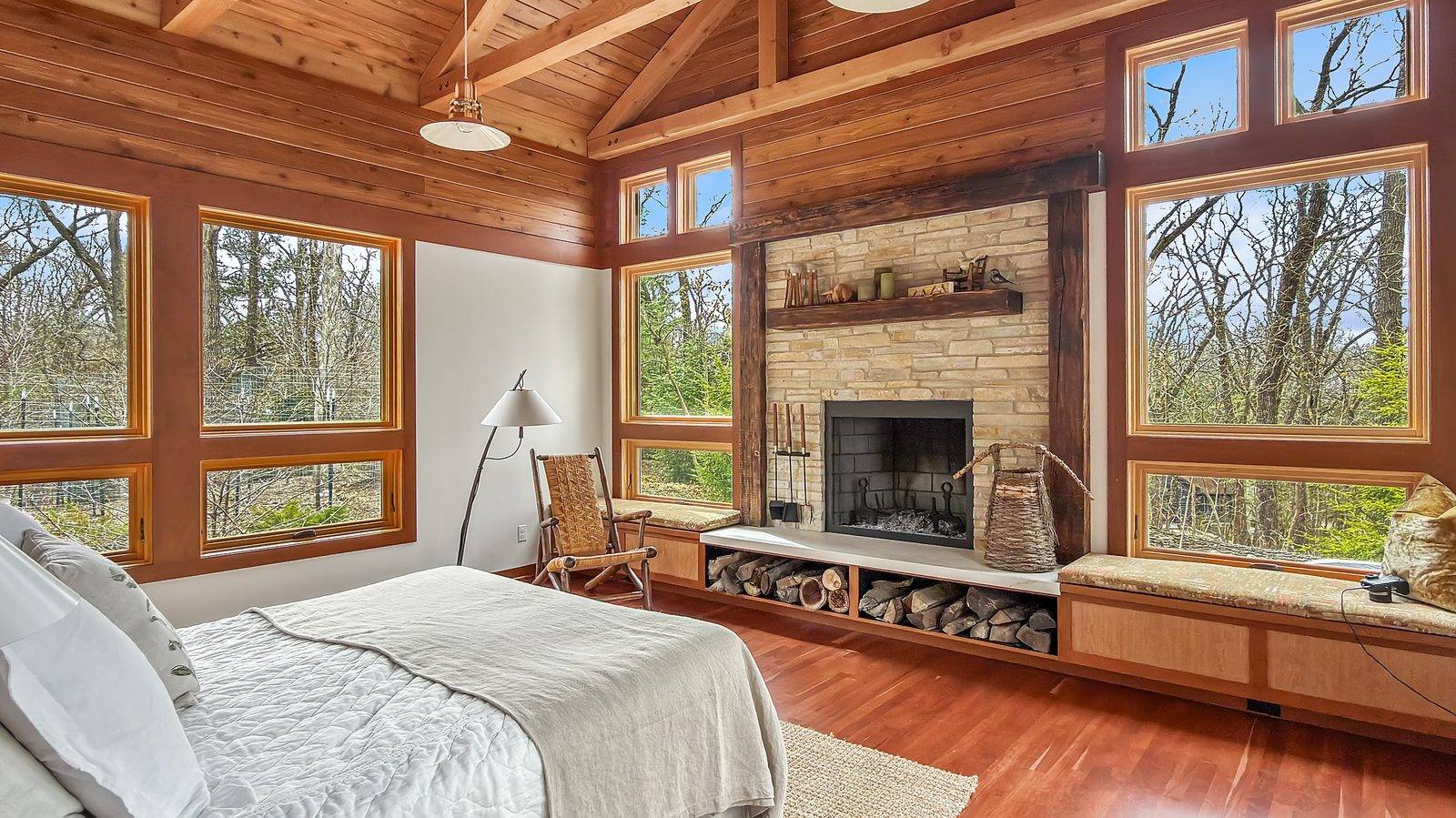 Bedroom with stone fireplace and vaulted ceiling